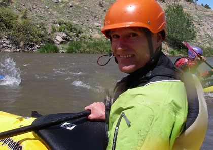 Kayaker in his boat alongside the river.